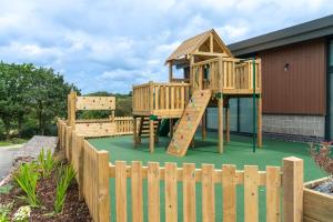 a playground with a wooden play structure at Camping Pods Hedley Wood Holiday Park in Bridgerule