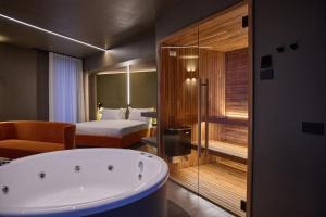 Habitación de hotel con bañera y cama en Le Agavi Resort & SPA, en Saludecio