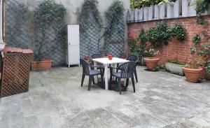 une table et des chaises assises sur une terrasse dans l'établissement Trilogy, à Valenza