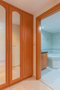 a bathroom with wooden cabinets and a bath tub at LUXFolio Retreats - Spacious Luxury Unit - 3BHK in Dubai