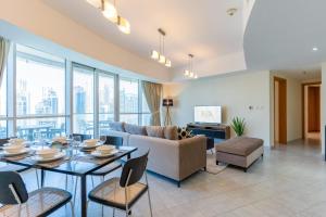 a living room with a table and a couch at LUXFolio Retreats - Spacious Luxury Unit - 3BHK in Dubai