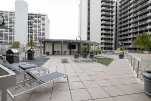 - un patio avec des chaises, des tables et des bâtiments dans l'établissement Located Crystal City Apt with Dazzling Amenities, à Arlington