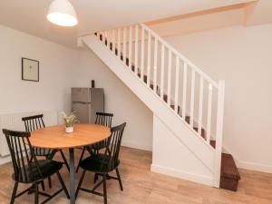 a dining room with a table and a staircase at Razorbill in Bridlington
