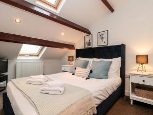 a bedroom with a large bed with towels on it at Razorbill in Bridlington