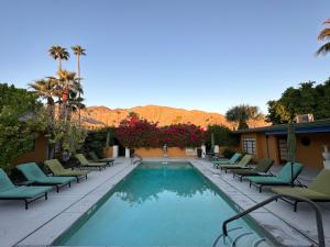 a swimming pool with chaise lounge chairs next to a resort at Vista Grande Resort - A Gay Men's Resort in Palm Springs