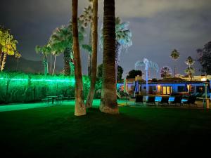 a resort with palm trees and a building with green lights at Vista Grande Resort - A Gay Men's Resort in Palm Springs