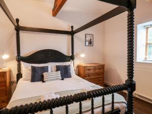 a bedroom with a black four poster bed at Guillemot in Bridlington