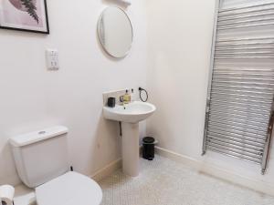 a white bathroom with a toilet and a mirror at Guillemot in Bridlington