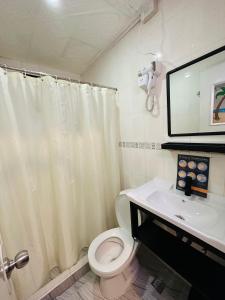 a bathroom with a white toilet and a sink at Sukhavati Inn in Baguio