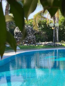 una piscina de agua azul en un patio en All'Ombra del Palmeto, en Taranto