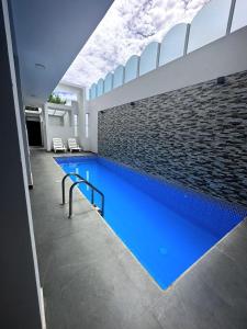 a large swimming pool with blue water in a building at la casa del encanto in Tarapoto
