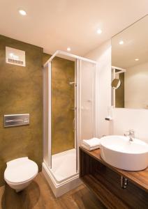 uma casa de banho com um WC, um lavatório e um chuveiro em Hotel Dachstein em Filzmoos