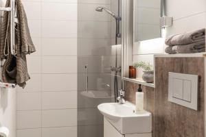 a white bathroom with a sink and a shower at Skoogs Logi - Rum in Funäsdalen