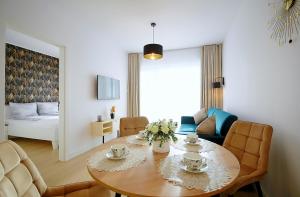 sala de estar con mesa y habitación con cama en Apartament Słoneczny Lux - Resort AQUA POLANKI - Baseny-Sauny-Siłownia-2023r en Kołobrzeg