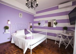 um quarto roxo e branco com uma cama e uma secretária em B&B Villa Ngiolò "vista mare" em Ancona