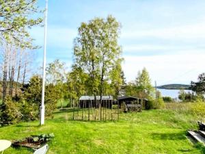 a house in a field of grass with a pole at Holiday home SANDÖVERKEN in Sandöverken