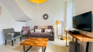 a living room with a couch and a tv at Superbe appartement en plein centre village in Saint-Martin-de-Ré