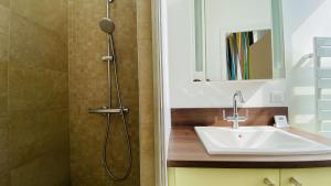 Un baño con lavabo y ducha en Superbe appartement en plein centre village, en Saint-Martin-de-Ré 2 fotos más