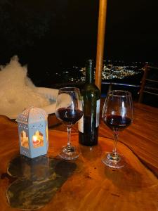 a table with two wine glasses and a bottle of wine at Senderos Glamping in Villavicencio +14 photos