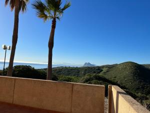 a retaining wall with palm trees and the ocean at Apto. Residencial La Alcaidesa in La Alcaidesa