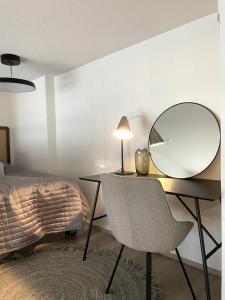 a bedroom with a desk with a mirror and a bed at Loft apartment with lake views in Tampere