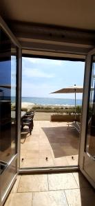 Pokój z przesuwnymi szklanymi drzwiami i widokiem na ocean. w obiekcie Résidence Pascal Paoli w mieście Moriani-Plage