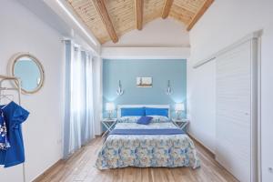 a blue bedroom with a bed and a wooden ceiling at LANTERNA DEL DELTA Guest House in Porto Tolle