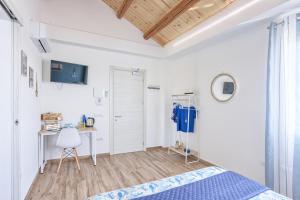 a white bedroom with a bed and a desk at LANTERNA DEL DELTA Guest House in Porto Tolle