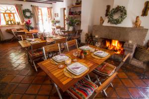 a dining room with a table and a fireplace at Las Casitas del Arco Iris in Urubamba