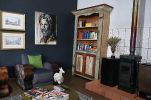 ein Wohnzimmer mit Sofa und Bücherregal in der Unterkunft 360 Country Hotel in Clarens