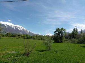 a green field with a snow covered mountain in the background at Famiglia nel vento in Caramanico Terme
