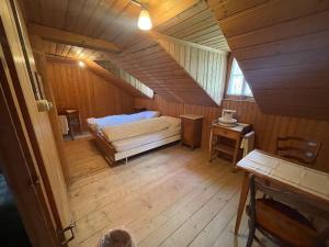 um quarto no sótão com uma cama num quarto de madeira em Berghotel Gasterntal em Kandersteg