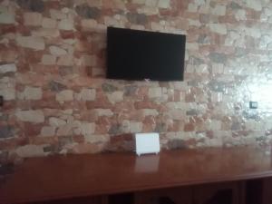 a television on a wall with a stone wall at Appartandalus in Larache