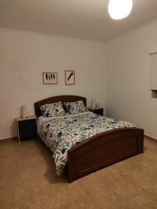 um quarto com uma cama com uma estrutura em madeira em Quinta da Ponte das Hortas 2 em Elvas