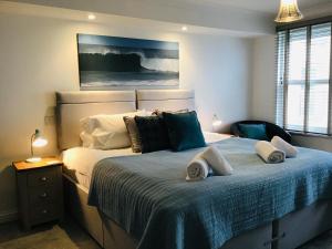 - une chambre avec un grand lit et des serviettes dans l'établissement 8 Spinnakers, à Newquay