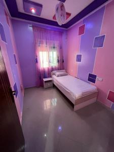 a pink room with a bed and a clock on the wall at Appartandalus in Larache