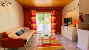 ein Wohnzimmer mit einem Sofa und einem TV in der Unterkunft Villa récente avec accès à la plage par chemin à l'arrière de la maison in Le Bois-Plage-en-Ré