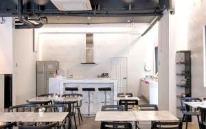 CANVAS BLACK Guesthouse في بوسان: مطعم فيه طاولات وكراسي في الغرفة