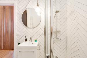 La salle de bains blanche est pourvue d'un lavabo et d'un miroir. dans l'établissement Hopstays Oporto Vibes - City Center Studio, à Porto