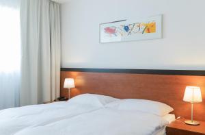 Schlafzimmer mit einem weißen Bett mit einem Kopfteil aus Holz in der Unterkunft Motel Gottardo Sud in Piotta