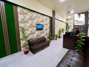 a lobby with a couch and a tv on a wall at Hotel 7 DHA in Karachi