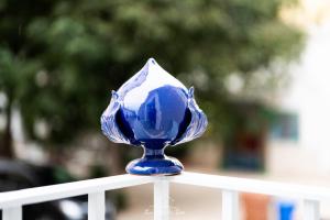 un jarrón de cristal azul sentado en la parte superior de una valla en LA CASA DI ZOE, en Manfredonia