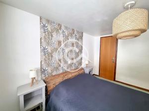 a bedroom with a blue bed and a curtain at Appartement Les Gets, 2 pièces, 5 personnes - FR-1-454-30 in Les Gets