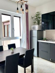 a kitchen with a table with chairs and a refrigerator at THE WHITE HOUSE, Modern apartment in Center in Milan
