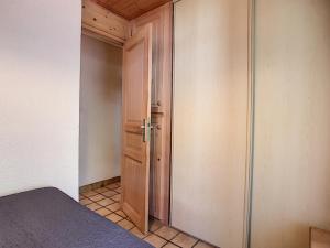レ・ジェにあるAppartement Les Gets, 2 pièces, 4 personnes - FR-1-454-33の木製のドアとクローゼット付きのベッドルーム1室