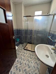 a bathroom with a glass shower and a sink at Appartandalus in Larache