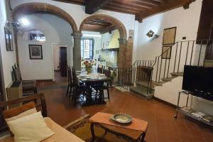 una gran sala de estar con una mesa y una escalera. en La Colonna - La Colonna, en Lucca