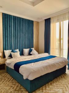 Schlafzimmer mit einem großen Bett und blauen Vorhängen in der Unterkunft شقق الكوثر الفندقية in Mekka