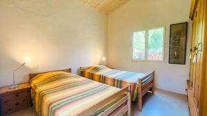 1 Schlafzimmer mit 2 Betten und einem Fenster in der Unterkunft Ensemble de 2 maisons dans les dunes in Le Bois-Plage-en-Ré