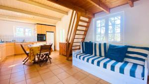 ein Wohnzimmer mit einem Sofa und einem Tisch in der Unterkunft Ensemble de 2 maisons dans les dunes in Le Bois-Plage-en-Ré